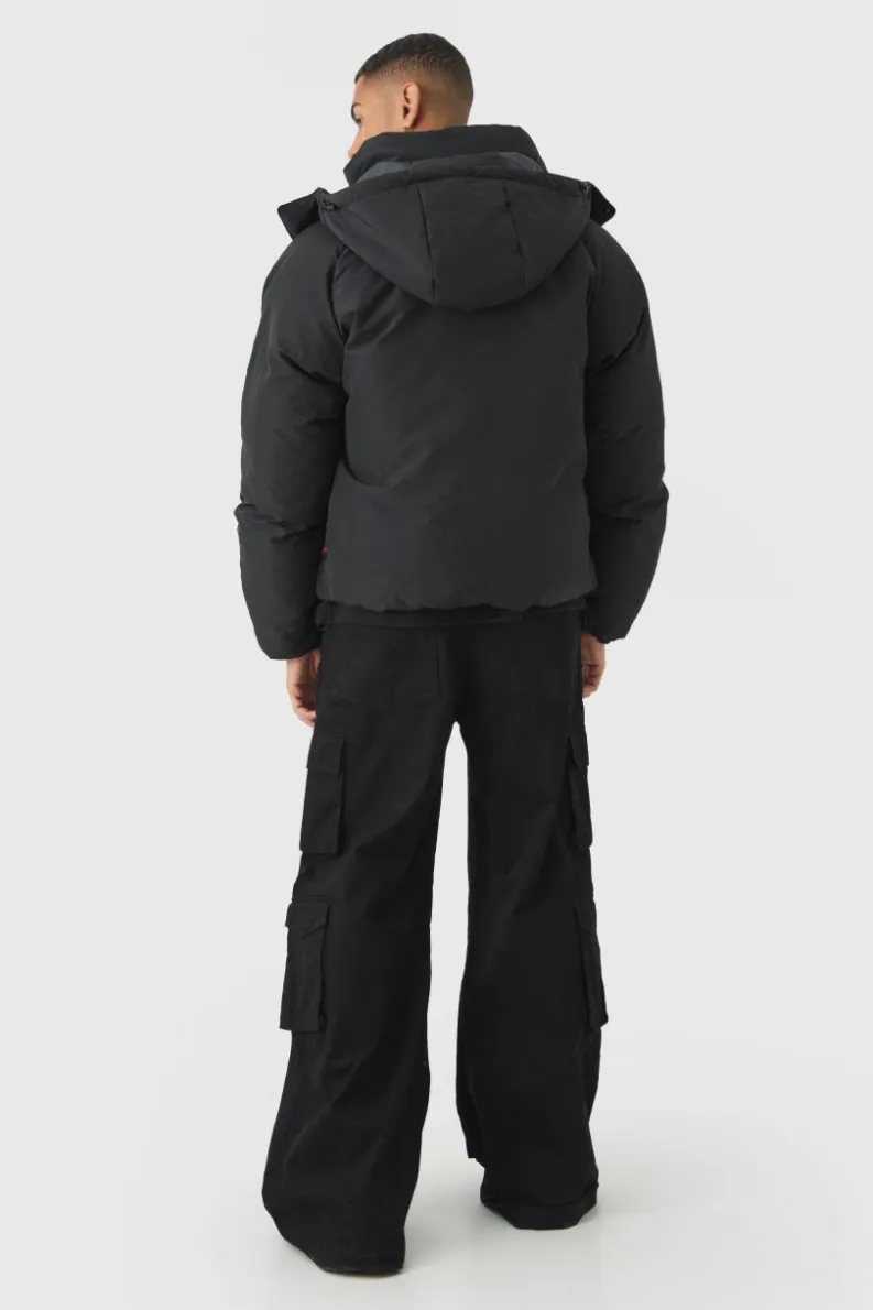 Store boohooMAN Gothic M Extreme Heavy Filled Hooded Puffer Coat In black