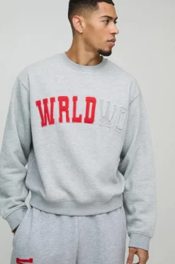 Shop boohooMAN Oversized Boxy Worldwide Distressed Applique Sweatshirt grey marl