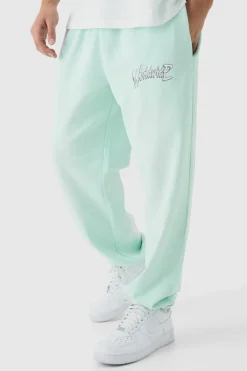 Shop boohooMAN Oversized Worldwide Spray Wash Printed Joggers turquoise