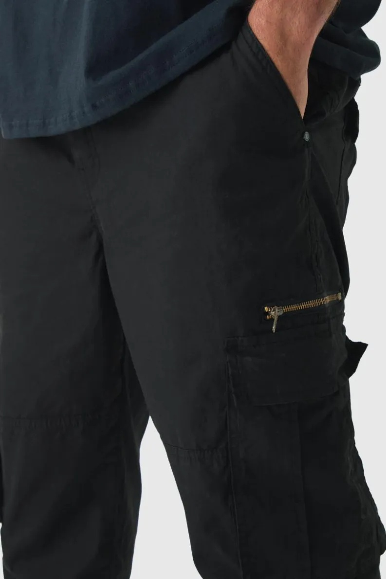 Shop boohooMAN Plus Slim Flare Zip Gusset Overdye Acid Wash Cargo Trouser In black