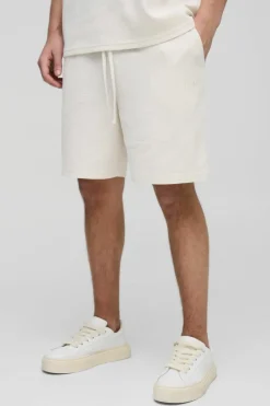 Shop boohooMAN Relaxed Man Embroidered Waffle Shorts ecru