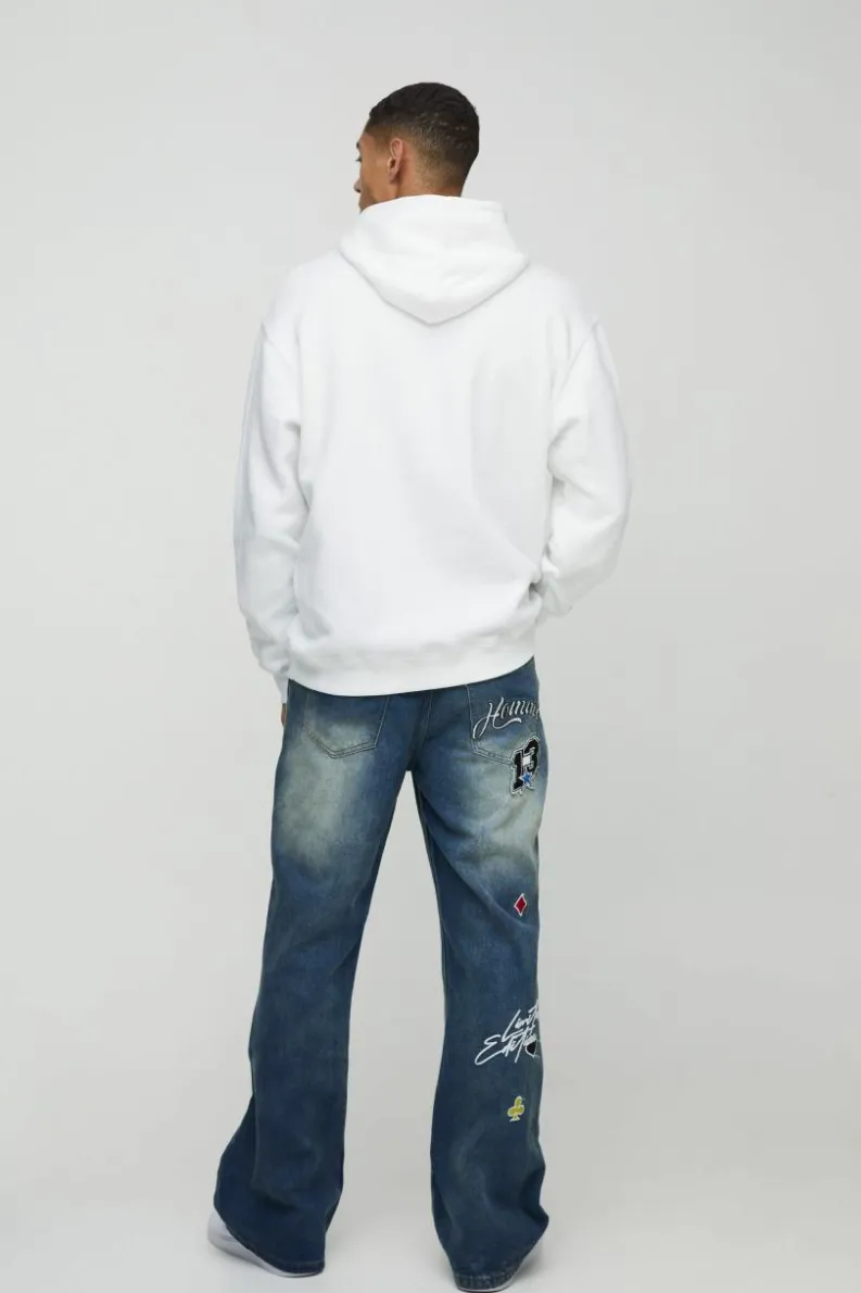 Store boohooMAN Relaxed Rigid Flared Gusset Varsity Applique Badge Jeans vintage blue