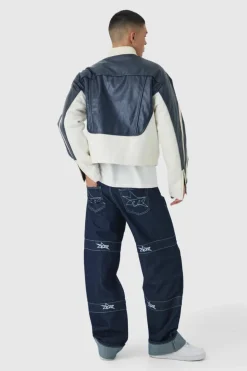 Shop boohooMAN Relaxed Rigid Contrast Embroidered Strap Turn Up Jeans indigo