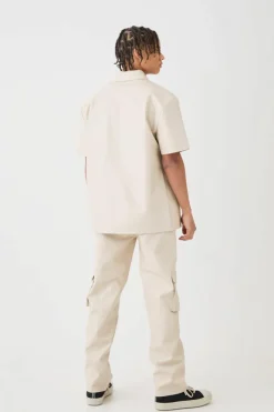 Shop boohooMAN Short Sleeve Drop Shoulder Pu Overshirt & Cargo Trouser Set beige