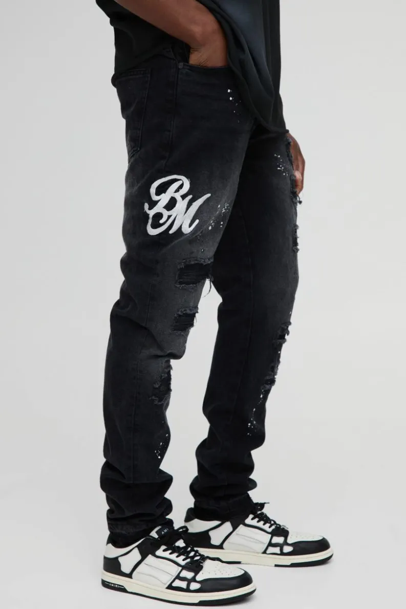 Shop boohooMAN Slim Rigid Paint Splat Ripped Jeans washed black