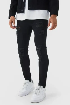 Store boohooMAN Super Skinny Jeans With All Over Rips true black